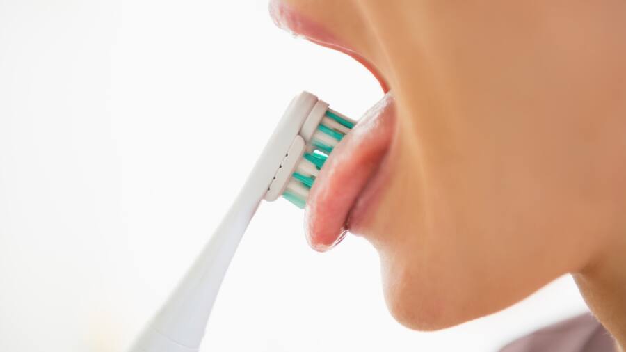 Vệ sinh lưỡi với cây cạo lưỡi để ngừa hôi miệng triệt để