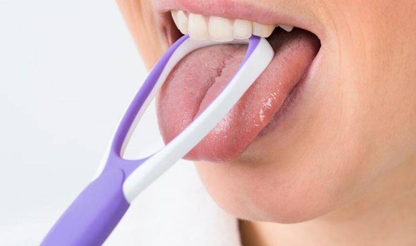 Làm sạch lưỡi với que cạo lưỡi bằng nhựa