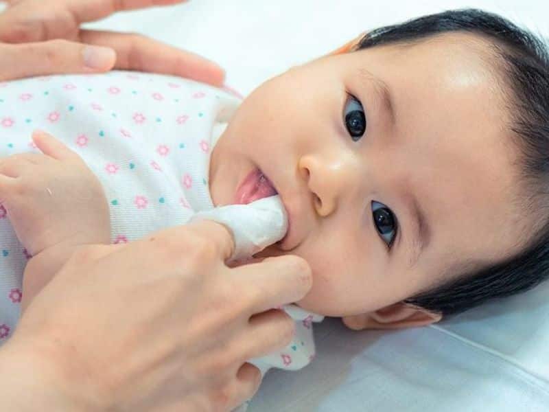 Vệ sinh răng miệng cho trẻ sơ sinh bằng khăn hoặc gạc ẩm